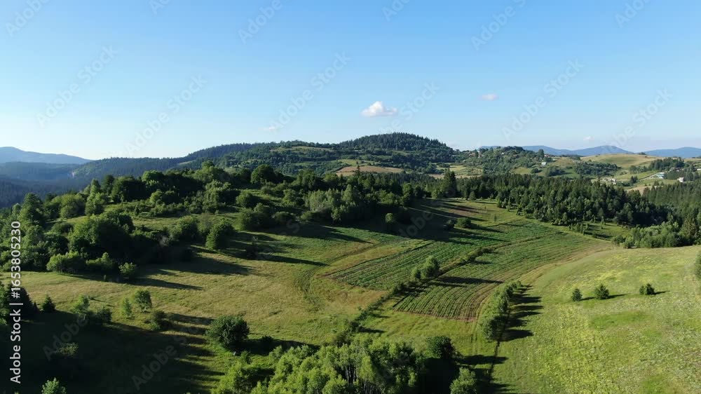 Aufkleber hills and trees under a clear sky with fields in a rural location the view extends to more hills and