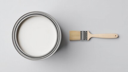 Closed white paint can and horizontal brush on light gray background, clean mockup with large left copy space