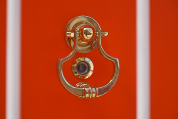 Elegant door knocker on a vibrant orange door