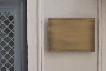 Empty signboard mounted on wall beside ornate door