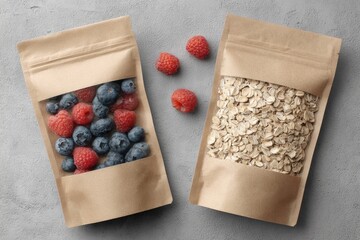 Two kraft paper pouches, one filled with raspberries and blueberries, the other with rolled oats, sit atop a gray surface