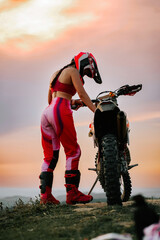 Rider prepares for off-road adventure against stunning sunset backdrop