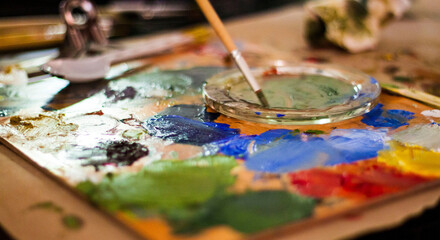 Thin paint brush and paint mix pad on  a table isolated