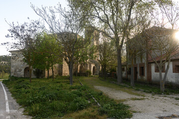 Side view of Iglesia de la Asuncion in Palacios del Alcor, Palencia, with bell tower and hillside
