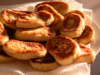 Delicious homemade pies resting on white paper towel illuminated by warm sunlight