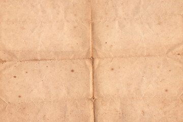 Folded Vintage Old Paper Texture Background. Weathered antique paper folded in four. Brown crumpled...