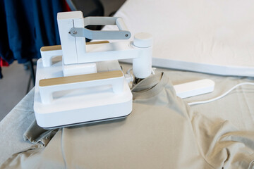 Modern Heat Press Machine Printing a T-Shirt in Workshop – Close-Up of Professional Fabric Pressing Equipment for Custom Apparel Production