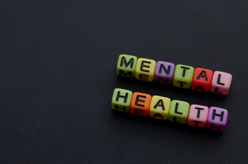 alphabet beads spelling out MENTAL HEALTH concept on white background, symbolizing psychological...
