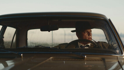 Detective smoking pipe driving vintage car