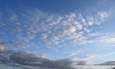 Blue sky with scattered clouds, symbolizing fresh air, freedom, and the benefits of nature for a healthy lifestyle, sport, tourism, and mental wellbeing.