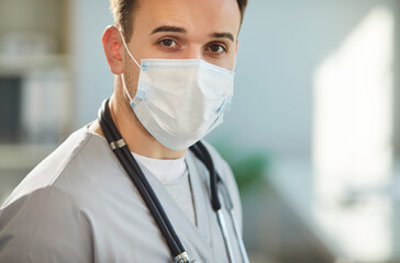 Physician, surgeon doctor, serious male nurse medical professional looking, wearing face mask,...