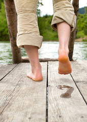 footprint on wooden pier in nature, barefoot on the boardwalk