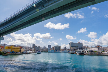 Fototapeta premium 沖縄県那覇市那覇泊港-2025/6/27 沖縄の海の玄関口、那覇泊港。 慶良間諸島の座間味島等へゆく高速ジェットフェリー。 クイーンざまみ3号に乗船した。 那覇泊港やとまりん、泊大橋が見える。 
