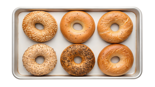Six assorted bagels on a baking tray isolated on transparent background