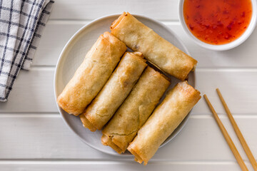 Fried spring rolls on plate on white table. Top view.