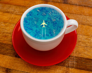 Take a travel like a cup of coffee! Travel concept of flying air plane above blue turquoise summer...