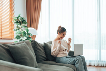 Funny euphoric young asian woman celebrating winning or getting ecommerce shopping offer on...