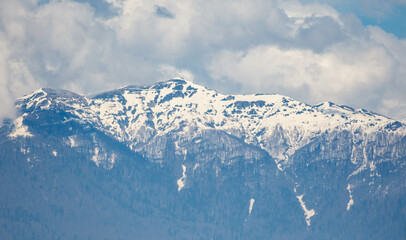 A mountain range covered in snow with a blue sky in the background