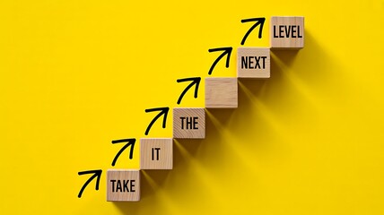 Wooden blocks with arrows showing take it to the next level concept
