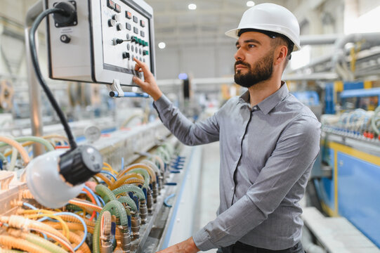 Engineer operating control panel in modern industrial factory
