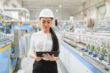 Female engineer using digital tablet in production line of modern factory