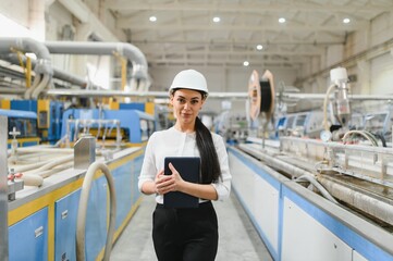 Female engineer holding tablet and supervising production line in window and door factory