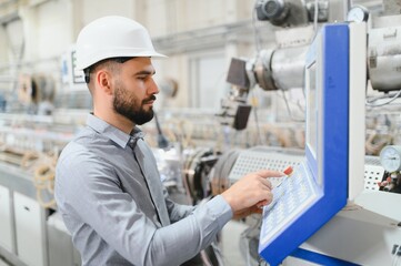 Industrial engineer operating machinery in modern factory