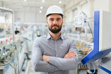 Engineer wearing hardhat crossing arms in pvc and aluminum window factory