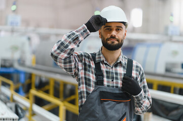 Industrial engineer adjusting hardhat in manufacturing factory