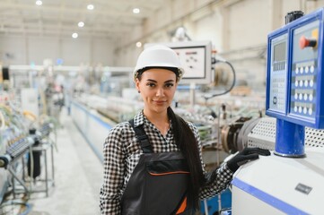Female industrial worker operating machinery in modern factory