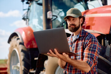 Agronomist using laptop while working in the field. © Drazen
