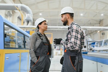 Industrial workers discussing production line strategy in factory