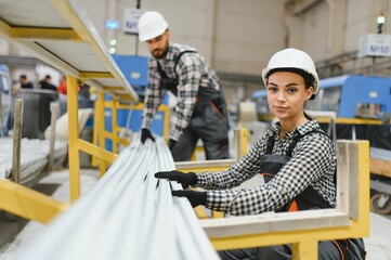 Factory workers handling pvc profiles for window and door production