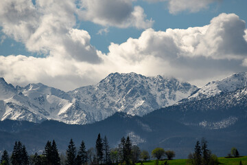 Snow-capped mountain peaks, white clouds in the sky, mountain view, Poland