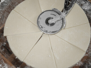 Cut triangles out of round dough and make croissants.