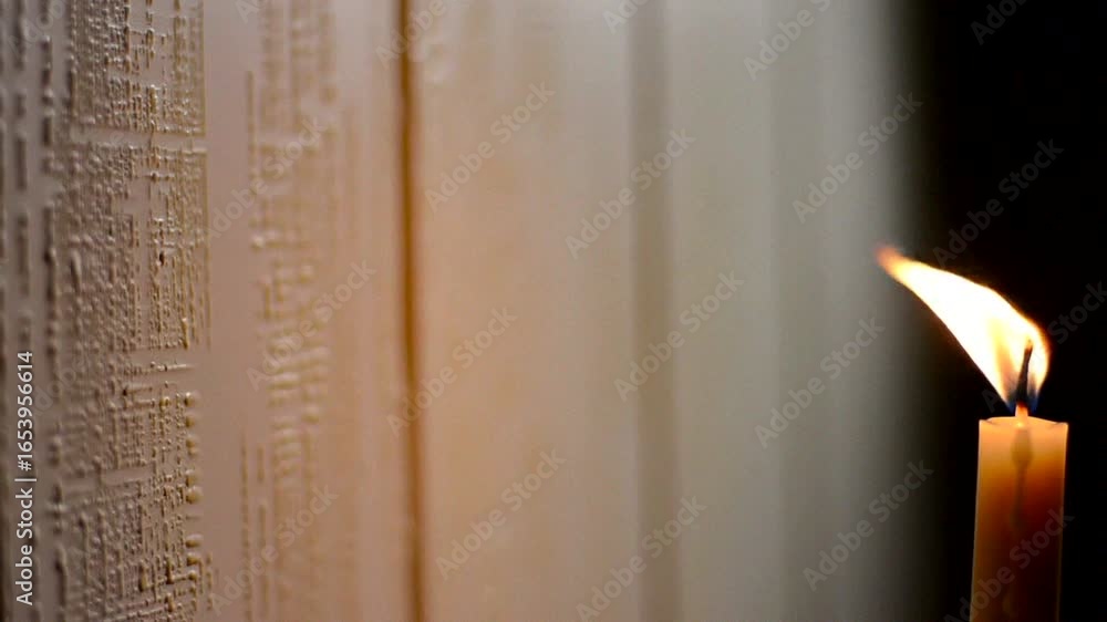 Poster a soft glow from a candle illuminates a textured wall, creating a serene and mystical atmosphere.
