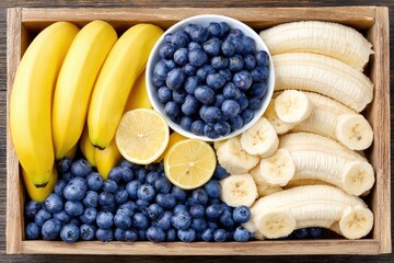 Wooden crate filled with fresh yellow bananas, blueberries, and lemon slices