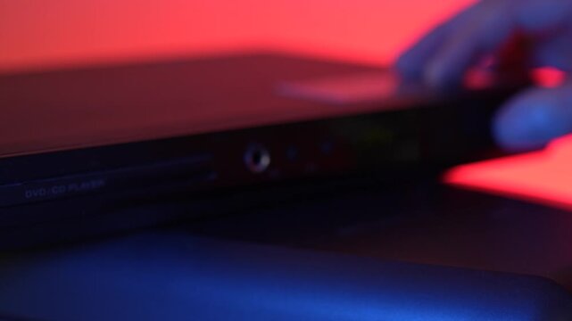 Man inserting disk into DVD player