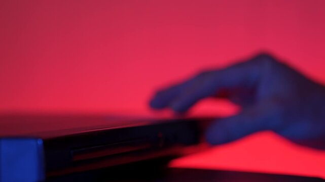 Man inserting disk into DVD player
