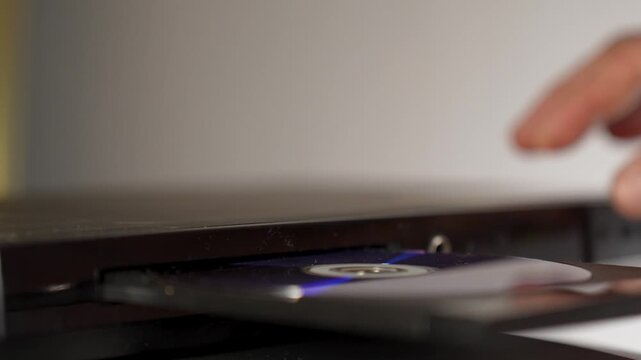 Man inserting disk into DVD player