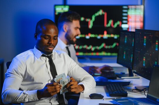 African american male stock trader or broker working at stock exchange office using computer