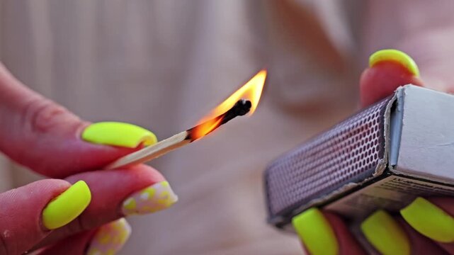 Steady flame on match captured in slow motion, fingers gently holding it