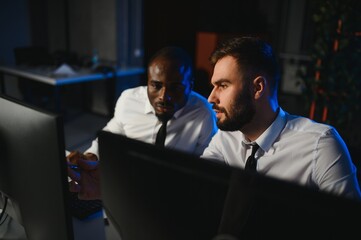 Conception of teamwork. Team of stockbrokers works in modern office with many display screens