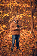 Amateur birdwatcher observing birds and other animals in nature with binoculars.