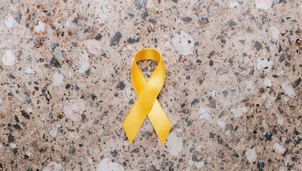 Golden Ribbon Awareness Symbol for Childhood Cancer on Textured Background.