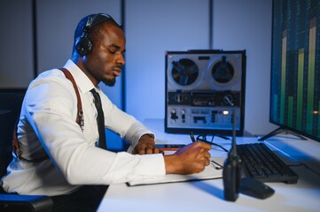 Secret agent listens on the reel tape recorder. Officer wiretapping in headphones