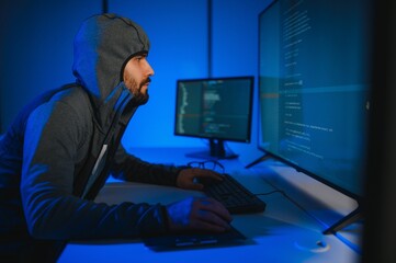 Hacker programmer using computer in dark room