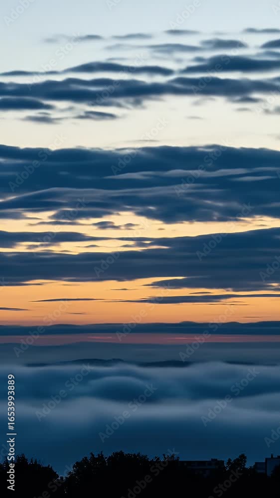 Poster golden hour sunset with rays through clouds over fog layer