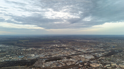 Aerial view of industrial area under cloudy sky with distant fields