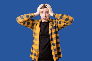 A man in a plaid shirt. Isolated portrait of a young man on a blue background